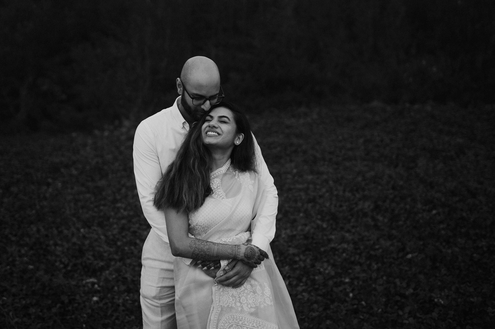 A couple embracing in a field at dusk